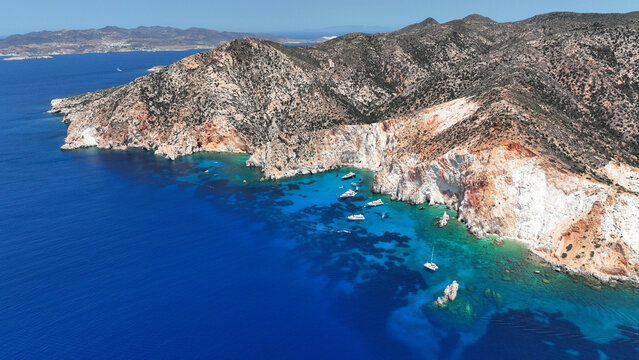 Aerial drone photo of paradise blue bay of uninhabited island of Polyaigos with turquoise crystal clear sea visited by luxury yachts and sail boats resembling a blue lagoon, Cyclades, Greece