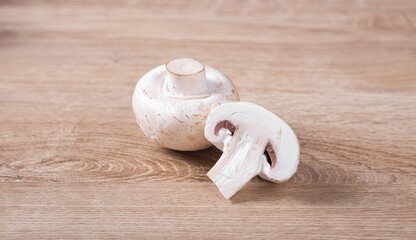 White champignons cut on wooden table in kitchen