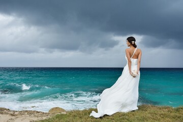 wedding in cuba, cuba, newlyweds on the ocean shore, honeymoon, standing on the ocean shore, wedding dress, lighthouse, atlantic ocean, caribbean sea