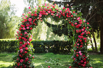 wedding arch decoration with roses in park with copy space