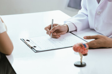 Asian male doctor consults with patient in clinic, reviews medical documents and uses stethoscope to diagnose health conditions, and confidently provides professional advice and care.