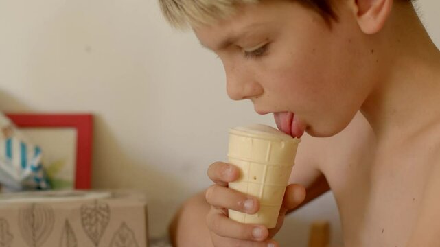 lick ice cream tongue teenager free time young boy joyfully enjoys a colorful ice cream cone at home, capturing pure joy and carefree innocence