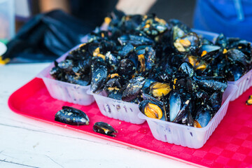 Close-up of 6 mariniere mussels servings on a red tray at 2024 