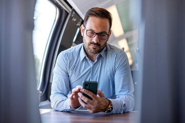Professional Businessman Using Smartphone on Train Journey