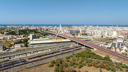 Obraz premium Aerial view of the Adriatic bridge in Bari, Puglia, Italy. It is a cable-stayed bridge that connects the city by passing over the railway. In the background is the Mediterranean Sea.
