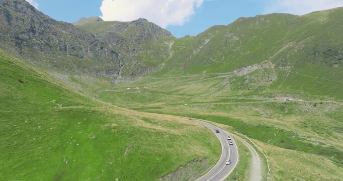 Top Down Aeriel Drone View of the Transfagarasan Highway in the Carpathian Mountains of Transylvania in summer with green grass. Winding Road with cars driving in 4K