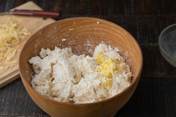 The process of making cottage cheese dough in the kitchen on a wooden table