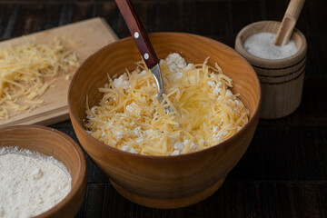 The process of making cottage cheese dough in the kitchen on a wooden table