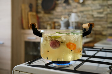Cooking pelmeni in boiling vegetable broth in transparent saucepan