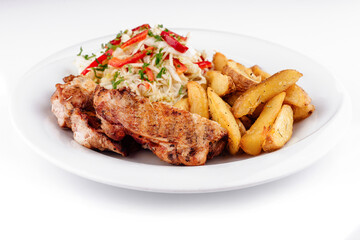 Grilled chicken breast serving with roasted potato wedges and salad on white plate