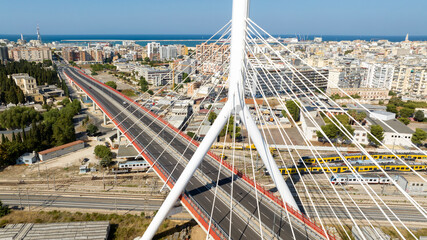 Obraz premium Aerial view of the Adriatic bridge in Bari, Puglia, Italy. It is a cable-stayed bridge that connects the city by passing over the railway. In the background is the Mediterranean Sea.