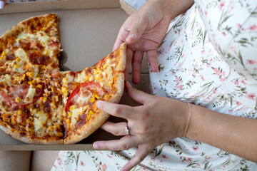 Woman taking piece of pizza