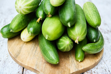Freshly harvested cucumbers piled on a wooden board for a healthy and organic snack