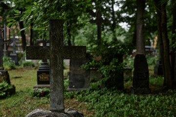 Background shot of concrete cross shaped tombstone covered with dirt and moss serving as lasting memorial to passed away standing in gloomy cemetery, copy space