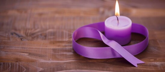 Purple ribbon for cancer awareness campaign with burning candle