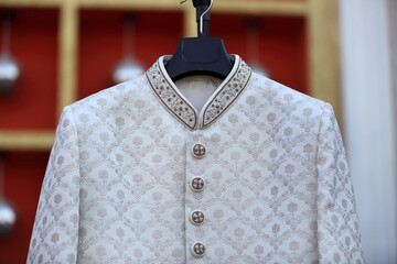A close-up of intricate floral embroidery on a rich fabric, intricate embroidery and pearls. The detailed craftsmanship showcases traditional Indian design elements, adding elegance.
