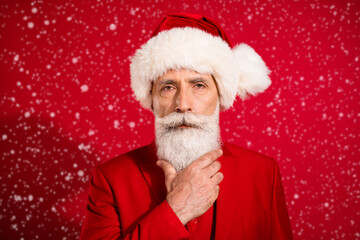 Photo of thoughtful charming mature man dressed christmas costume glarm chin isolated red color...