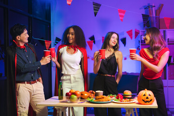 Dinner and group of people celebrating together at Halloween party. Friends are happy and celebrating with food, wine and friendship of love and cheers of champagne at the event.