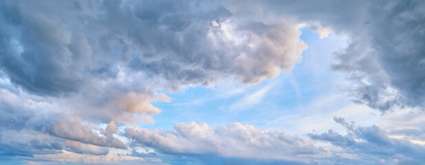 Obraz premium Panorama of cloudy sky with blue patches of clear sky