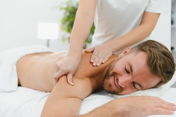 Handsome middle-aged man enjoying relaxing spa massage with oils