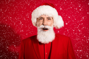 Photo of shocked speechless santa claus open mouth wtf grimace wear x-mas hat tuxedo on red color background