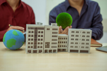 Two businessmen work at desks in an office,discussing city clean energy strategies global...