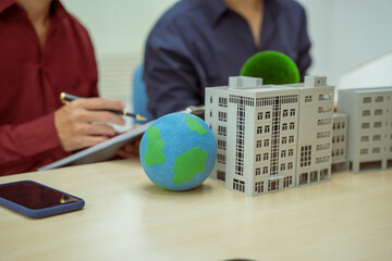Two businessmen work at desks in an office,discussing city clean energy strategies global...