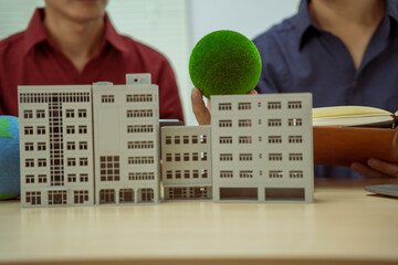 Two businessmen work at desks in an office,discussing city clean energy strategies global...