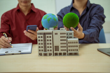 Two businessmen work at desks in an office,discussing city clean energy strategies global...