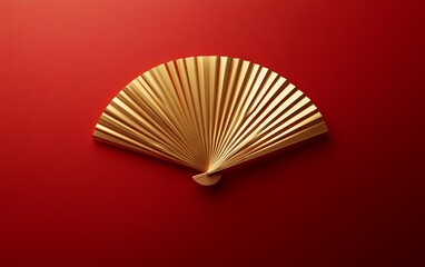 A single, golden fan floating against a rich red background in minimalist style