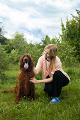 A young girl student is petting and feeding and playing with her pet dog in backyard. High quality...