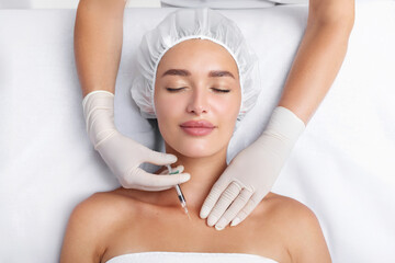 Young beautiful woman getting hyaluronic acid injections in her chest skin, receiving skin...