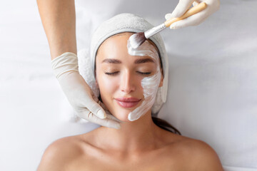 Top view of young woman enjoying luxury professional facial mask treatment. Day at spa, beauty...