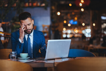 Stressed Businessman Working in a Busy Cafe Environment