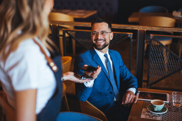 Businessman Smiling in Cafe Interacting with Friendly Waitress