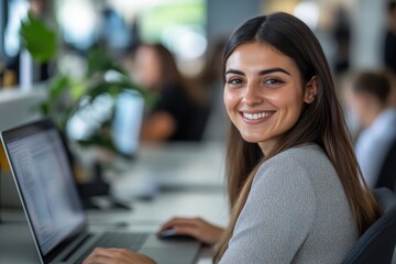 Photo of a smiling businesswoman using a laptop while sitting at a desk in an office, working on a computer and smiling at the camera during a workday,generative ai