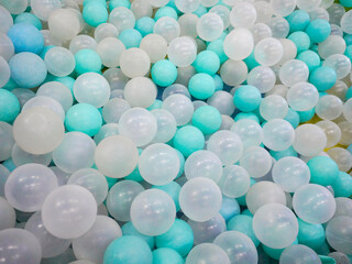 a pile of cyan, white, and transparent plastic balls in the ball pool at the Children's Playground