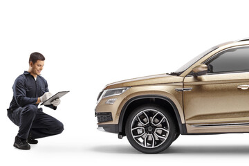 Auto mechanic kneeling and checking a SUV