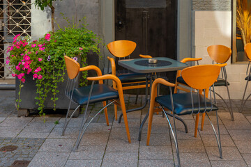 wooden table with four chairs and a potted plant in front of it