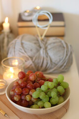 Pumpkins, various food and drinks, fall decorations, books and candles on the table. Fall hygge at home. Selective focus.