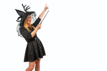 Blonde woman wearing a witch costume is pointing with her magic wand and casting a spell