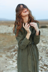 Joyful woman celebrating in the vast desert with arms raised in the air