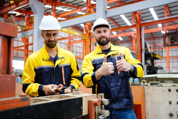 Male engineer works and inspects machinery at a metal sheet factory.