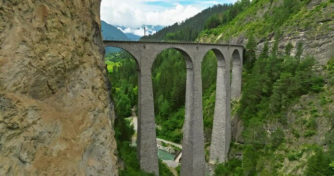 Railway scenic route in Switzerland. Express red swiss train in Swiss Alps. Landwasser Viaduct world heritage sight with luxury Glacier and Bernina express summer scenery