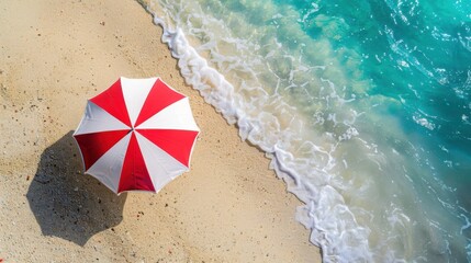 a red and white umbrella is on top of sand at the beach