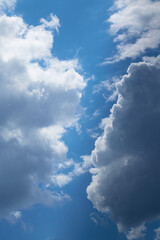 Two clouds in the sky light and dark close-up vertical image