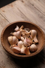 Allium sativum. garlic on a wooden bowl. wooden table. 