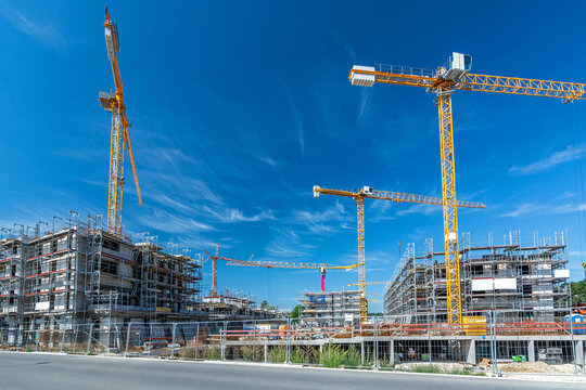 Large construction site with several cranes, foundations and buildings