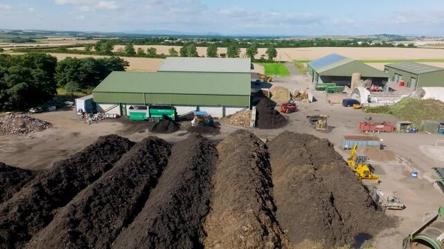 Aerial view of composting site with machinery and compost piles in rural landscape, East Linton, Scotland.