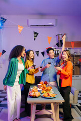 A diverse group of coworkers enjoying a casual office party or home with drinks, food,